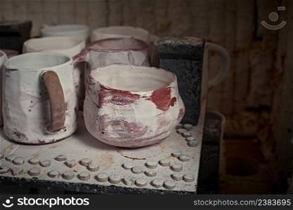 clay mugs in kiln for firing pottery in pottery studio.. clay mugs in kiln for firing pottery 