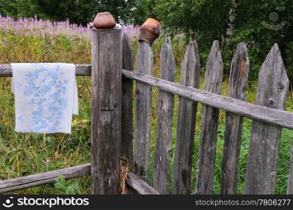 Clay pots and towel on the fence in the Russian village