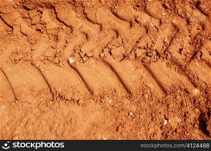 Clay red dried soil with tractor tires footprint