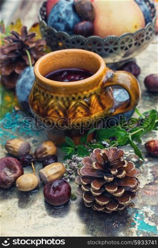 clay tea cup background of harvest of autumn fruits.