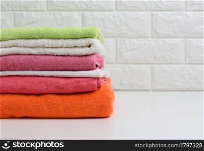 clean folded terry towels on white shelf, bathroom interior