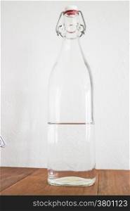 Clean glass bottle half of water, stock photo