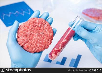 Clean ground meat sample burger patty in lab scientist hand. Artificial cultured meat in laboratory test tube comparison concept.