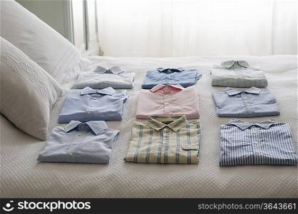 Clean shirts ordered on a bed