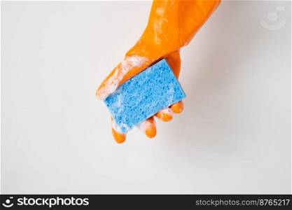 Cleaner concept, Hand in orange rubber gloves and holding light blue sponge with foam for cleaning.