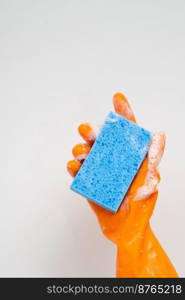 Cleaner concept, Hand in orange rubber gloves and holding light blue sponge with foam for cleaning.