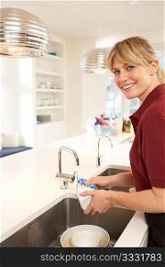 Cleaner Working In Domestic Kitchen