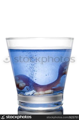 Cleaning a denture in a glass with water.Proper of hygiene.