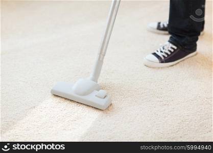 cleaning and home concept - close up of male hoovering carpet. close up of male hoovering carpet