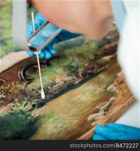 Cleaning and restoration of an old oil painting, surface cleaning process. Old Oil Painting Cleaning and Restoration