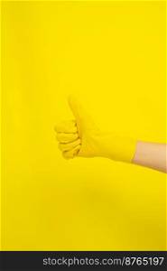 Cleaning concept, Hand in rubber gloves and doing thumb up symbol isolated on yellow background.