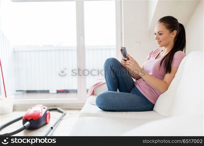 cleaning, household and technology concept - happy woman or housewife with smartphone and vacuum cleaner at home. woman with smartphone and vacuum cleaner at home. woman with smartphone and vacuum cleaner at home