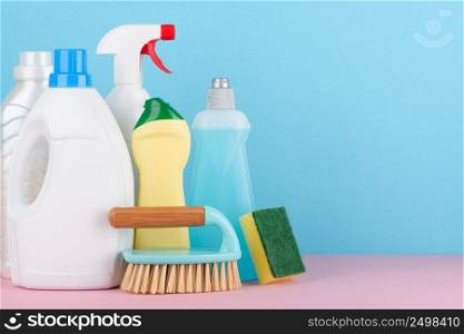 Cleaning liquids and tools set for different housework. Bathroom, kitchen, office house cleaning service equipment on pastel background with copy space.