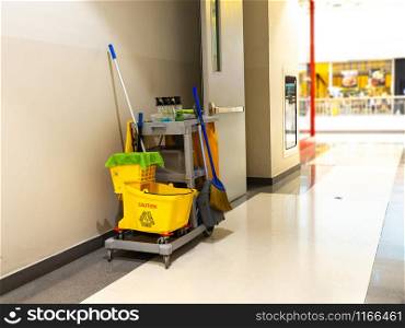 Cleaning tools cart wait for maid or cleaner in the department store. Bucket and set of cleaning equipment in the mall. Concept of service, worker and equipment for cleaner and health