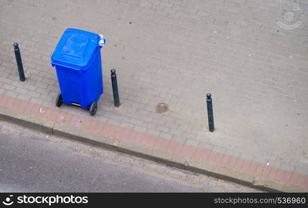 Cleanliness in city objects concept. Minimalist photo of blue trash can on street pavement. Blue trash can on street pavement