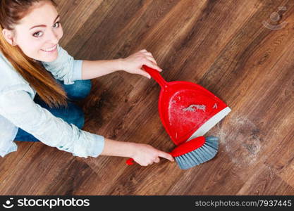 Cleanup housework concept. cleaning woman sweeping wooden floor with red small whisk broom and dustpan unusual high angle view