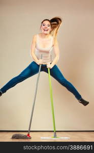 Cleanup housework concept. Funny cleaning lady young woman mopping floor, holding two mops new and old jumping