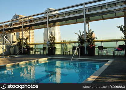 Clear blue pool overlooking skyscrapers near sunset