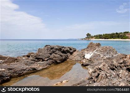 clear blue sea and volcanic rocky shore