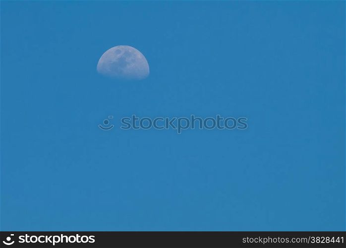 Clear blue sky with half moon in the day time
