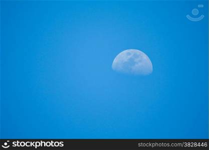 Clear blue sky with half moon in the day time