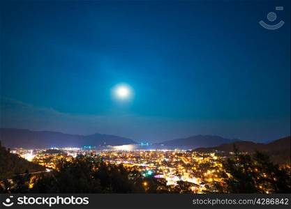 clear sky and full moon over night city