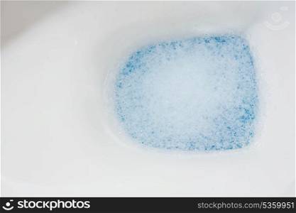 clear toilet bowl closeup with blue water