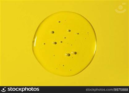 Clear transparent round liquid gel drop or smear isolated on yellow background. Top view. Virus protection or cosmetics concept. Serum texture. Clear transparent round liquid gel drop or smear isolated on yellow background. Top view. Virus protection or cosmetics concept. Serum texture.
