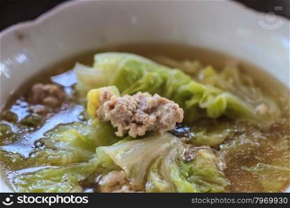 Clear vegetable soup with minced pork close up