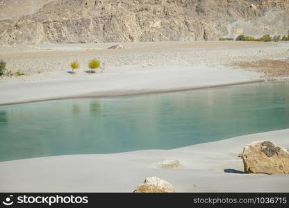 Clear water of Shyok River flowing along the sand beach in Ghanche. Gilgit Baltistan, Pakistan.