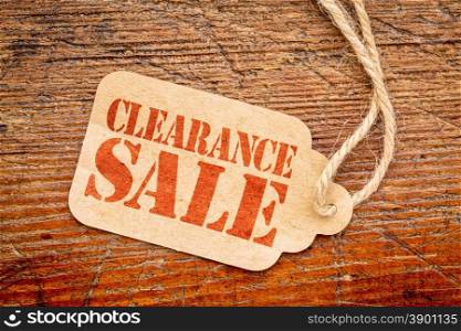 clearance sale sign a paper price tag against rustic red painted barn wood