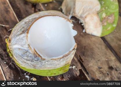 Cleaved fresh coconut on wooden table