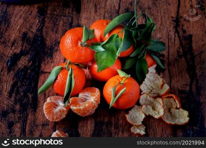 Clementines with leaves on an old wooden table