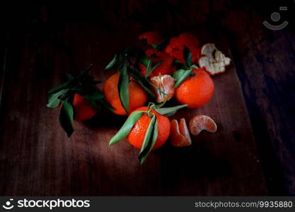 Clementines with leaves on an old wooden table