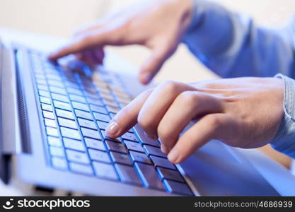 Click! Hands of a man on a keyboard with blue backlighting.