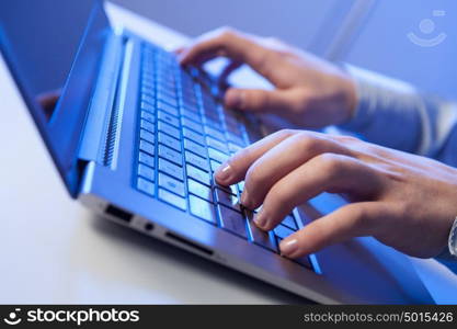 Click! Hands of a man on a keyboard with blue backlighting.