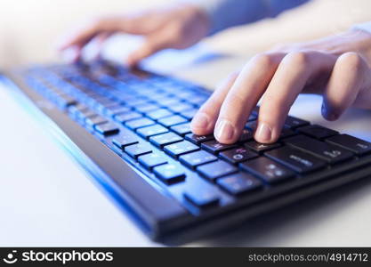 Click! Hands of a man on keyboard. Click! Hands of a man on a keyboard with blue backlighting.