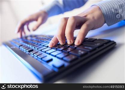 Click! Hands of a man on keyboard. Click! Hands of a man on a keyboard with blue backlighting.