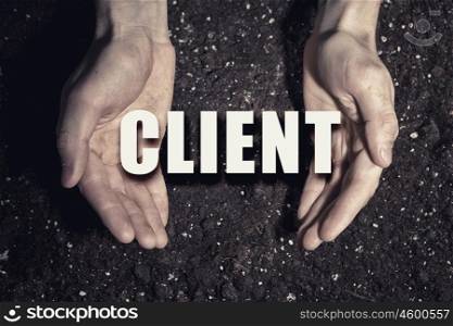 Client oriented approach. Male hands on soil background showing in palms idea word client