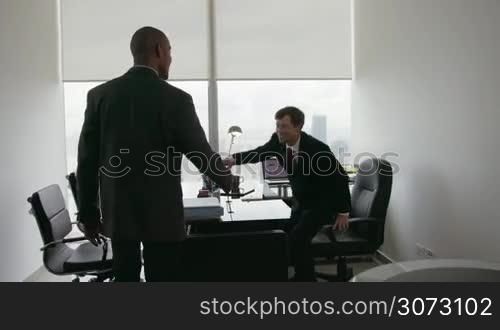 Clients meeting with consultant in corporate office. The team of business people shakes their hands and sit down talking. Medium shot, Steadicam