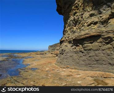 cliff and tidal platform with blue sky. cliff and tidal platform with blue ocean and deep blue sky in the background