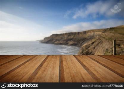 Cliffs landscape stretching out to sea in Summer with wooden planks floor