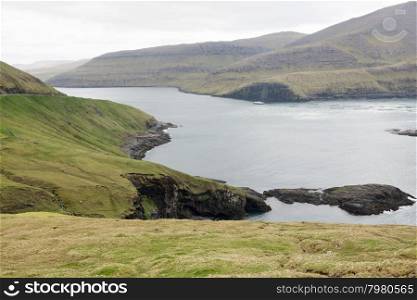 Cliffs on Vagar. Cliffs on Vagar Island on the Faroe Islands with salmon farm