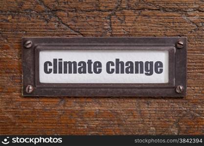climate change - file cabinet label, bronze holder against grunge and scratched wood