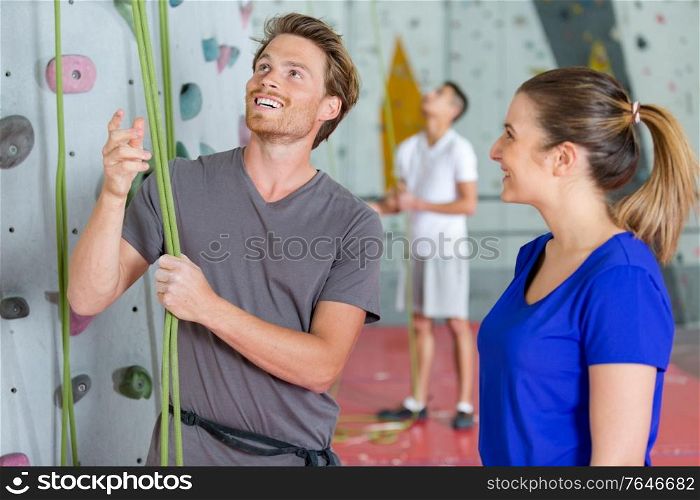climber checking ropes before climbing indoor wall