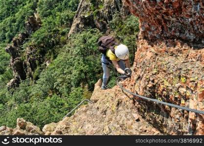 climber on a exposed ridge in Via Ferrata degli Artisti, Liguria, Italy