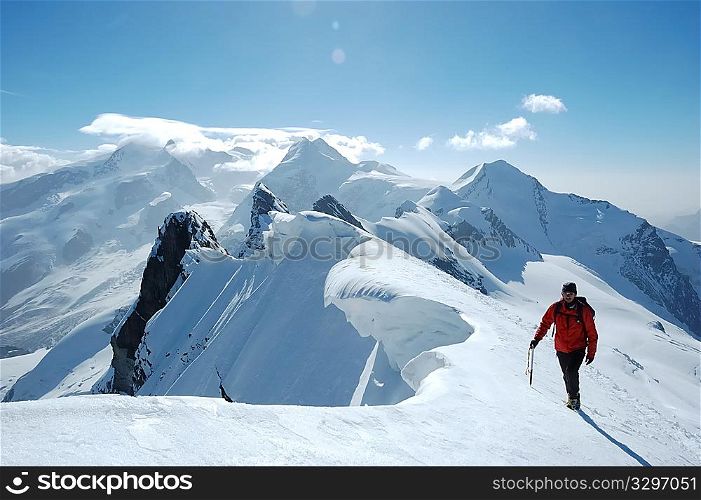 Climber on background the peaks and glaciers of Monte Rosa massif, west Alps, Europe