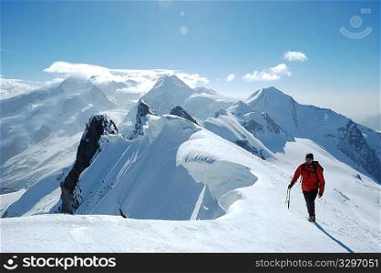 Climber on background the peaks and glaciers of Monte Rosa massif, west Alps, Europe