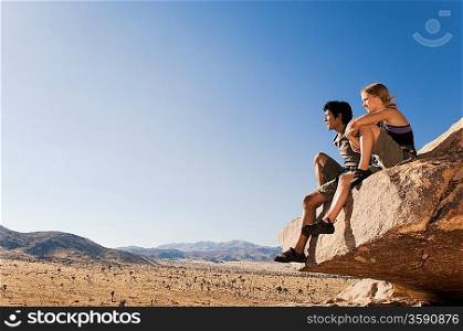 Climbers on Rock Looking at Desert
