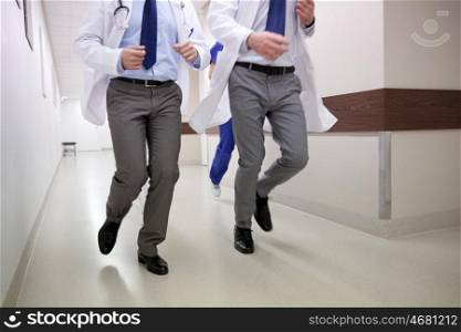 clinic, emergency, people, healthcare and medicine concept - close up of medics or doctors running along hospital corridor